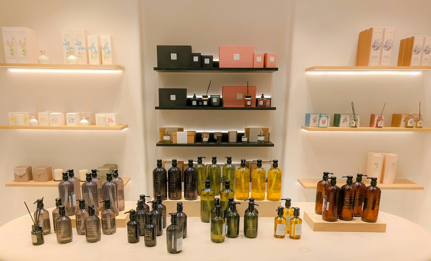 Beauty products displayed on shelves and table in a store.
