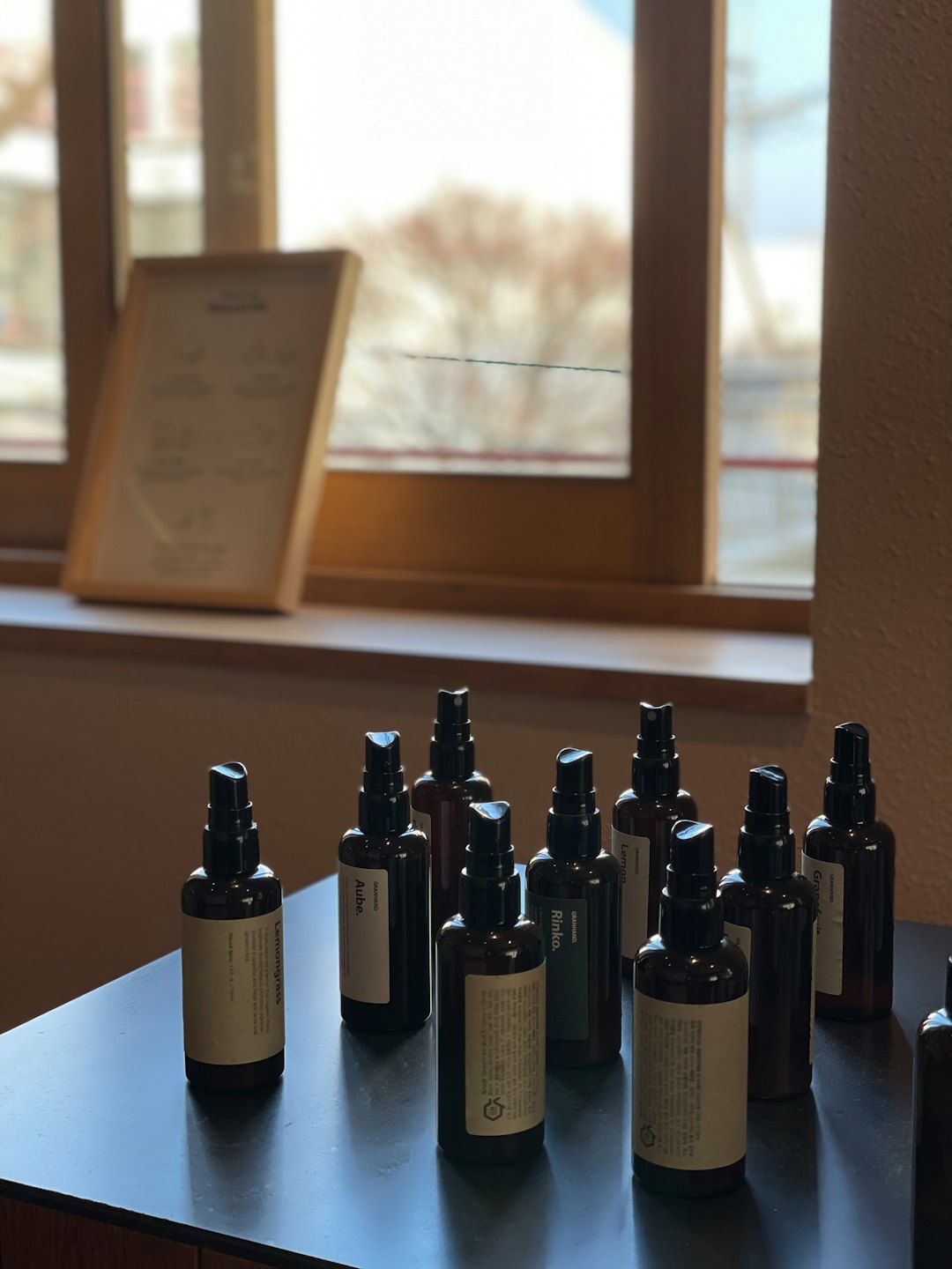 Amber spray bottles arranged neatly on a dark wooden table.